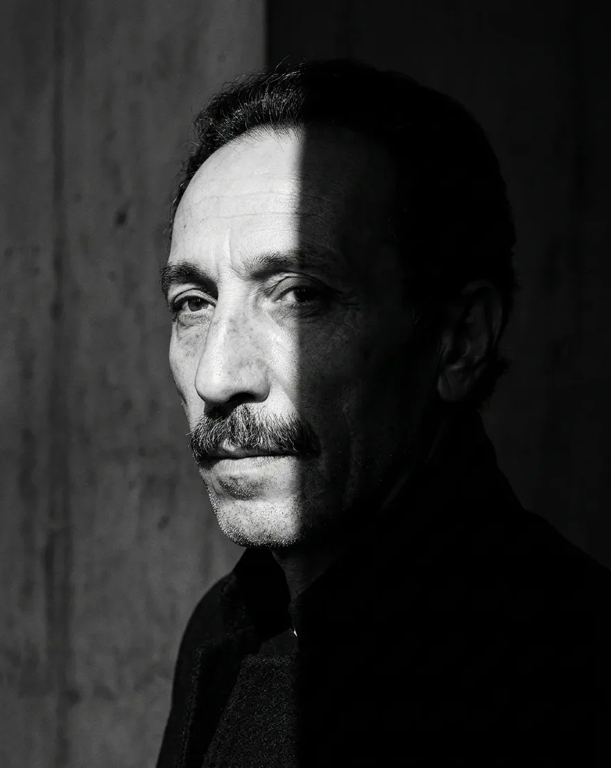 Black-and-white portrait of Father Tanrıverdi, half in shadow.